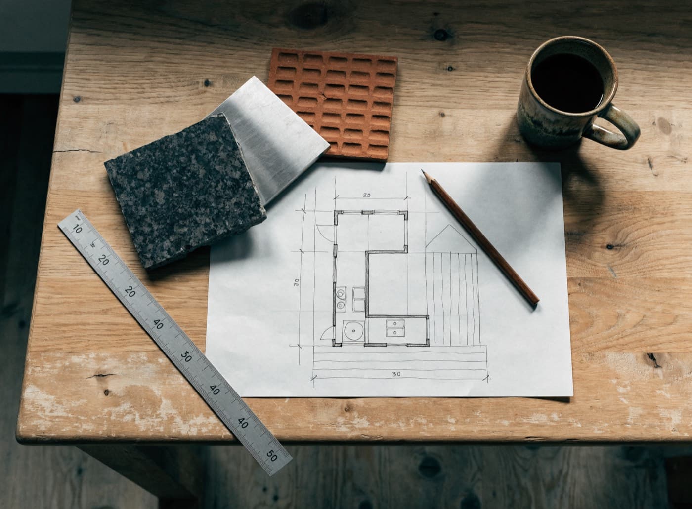Plattegrond van een buitenkeuken met materiaalstalen op een werkbank
